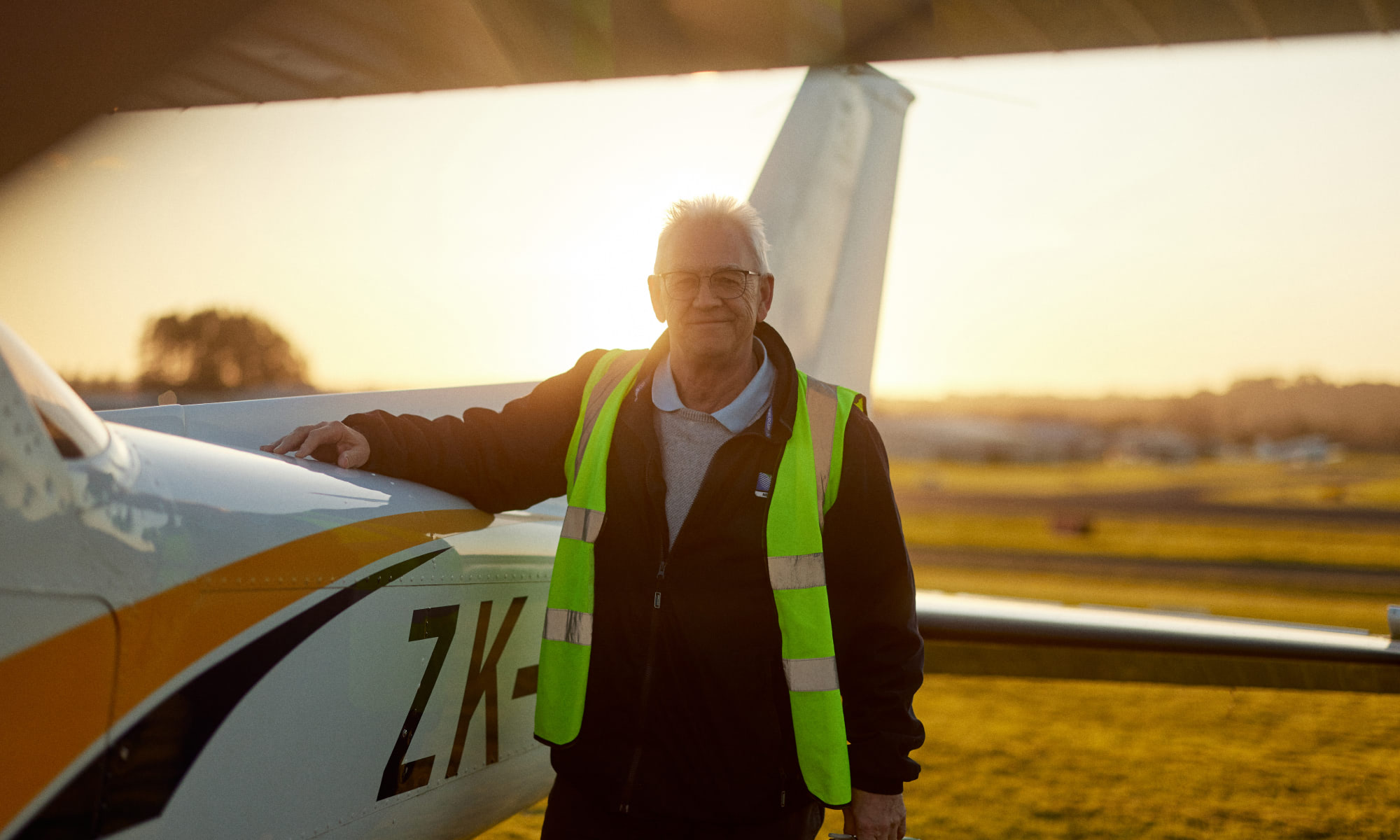Man holding plane with sunset